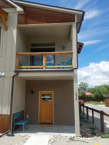 una casa con balcone e porta in legno di The Osprey House! On The River Str#360 a Salida