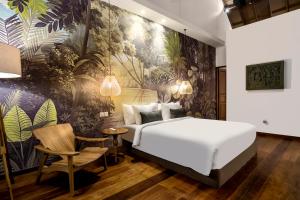 1 dormitorio con 1 cama y un mural en la pared en Nusantara Loft Rote by Alfred in Bali, en Canggu