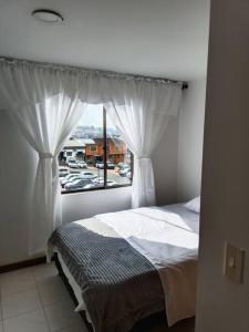 Schlafzimmer mit einem Bett und einem Fenster in der Unterkunft Excelente ubicación y acogedor apartamento in Manizales