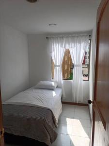 Schlafzimmer mit einem Bett und einem Fenster in der Unterkunft Excelente ubicación y acogedor apartamento in Manizales