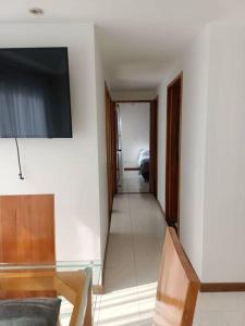 ein Wohnzimmer mit einem TV an der Wand in der Unterkunft Excelente ubicación y acogedor apartamento in Manizales