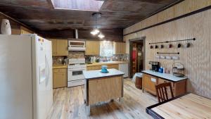 a kitchen with wooden floors and a white refrigerator at Line Shack On Tenderfoot Trail With High Speed Wifi in Red River