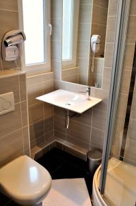 a bathroom with a sink and a toilet at Hotel Le Croiseur Intra Muros in Saint Malo