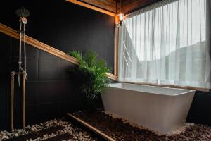 a bath tub in a bathroom with a window at JADAE HOUSE Doichang in Ban Huai Khai