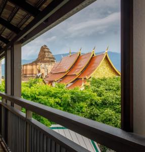 a view from a balcony of a building and temples at Chala Number6 in Chiang Mai