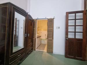 baño con puerta de madera y baño con lavabo en Katie's homestay en Ðông Mỹ (2)