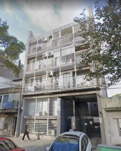 un hombre caminando delante de un edificio en Departamento con cochera en Rosario en Rosario