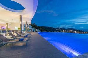 a pool on the roof of a building at night at The View Phuket in Kata Beach