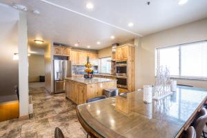 a large kitchen with a large wooden table and a counter at Majestic Suite 5 Bedroom Brighton Chalet in Brighton