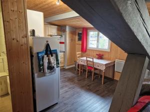 eine Küche und ein Esszimmer mit einem Kühlschrank und einem Tisch in der Unterkunft Appartement Mont-Dore, 2 pièces, 4 personnes - FR-1-415-109 in Le Mont-Dore