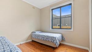a bedroom with a bed and a window at Beach Heaven in Hawks Nest