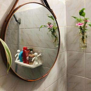 a round mirror on a wall in a bathroom at Mika Homestay Simple & Cozy in Hanoi