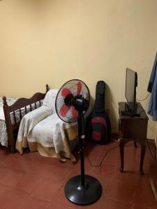 a room with a fan in front of a bed at Habitación en casa Familiar in León