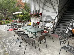 een groep tafels en stoelen met bloemen en trappen bij Country Homestay in Guoxing