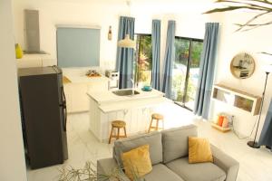 a living room with a couch and a kitchen at Villa Luce in Las Terrenas
