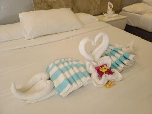 twee zwanen gemaakt van handdoeken op een bed bij 버진 아일랜드 리조트 Virgin Island Resort Restaurant & Spa in Panglao