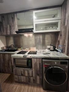 a kitchen with a stove and a dishwasher at Vunna Apartemen pollux habibi in Batam Center +7 photos