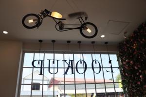 a bicycle chandelier hanging from the ceiling of a restaurant at LOOK UP CAFE INN in Siem Reap
