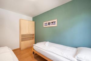 Zimmer mit einem Bett und einer blauen Wand in der Unterkunft Between Lakes Apartments - 58 in Interlaken