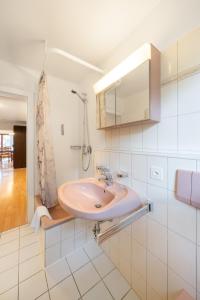 ein Bad mit einem Waschbecken und einem Spiegel in der Unterkunft Between Lakes Apartments - 58 in Interlaken