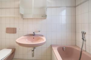 y baño con lavabo y bañera. en Between Lakes Apartments - 58, en Interlaken