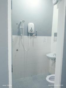 a bathroom with a shower with a toilet and a sink at BASE HOTEL in Kuala Kubu Bharu