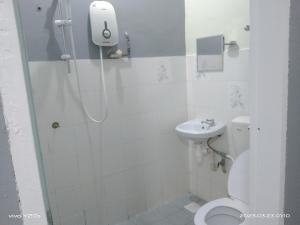a bathroom with a shower and a toilet and a sink at BASE HOTEL in Kuala Kubu Bharu