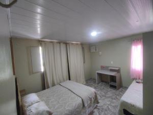 um quarto com 2 camas, uma secretária e uma janela em Casa espetacular próximo ao Museu da Amazônia em Manaus