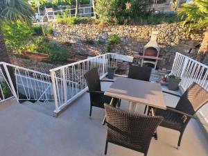 a patio with chairs and a table and a grill at Apartment Beautifull View in Rabac