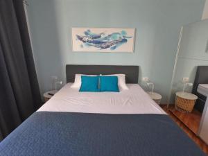 a bedroom with a large bed with blue pillows at Apartment Beautifull View in Rabac