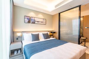 a bedroom with a large bed and a shower at Chongqing Yitang Hotel Apartment in Chongqing