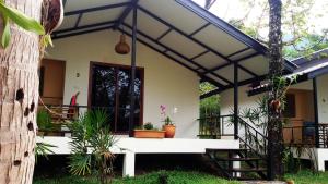 ein Haus mit einer Veranda und einer Treppe davor in der Unterkunft Lucky Gecko Garden in Ko Chang