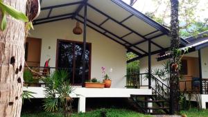 une maison avec une terrasse couverte et un escalier en face de celle-ci dans l'établissement Lucky Gecko Garden, à Ko Chang