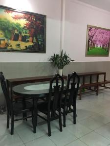 a dining room with a table and chairs and a painting at Homestay 484 in Pleiku