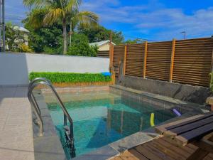 - une piscine avec une clôture en bois et une piscine dans l'établissement Lilie location langevin, à Saint-Joseph