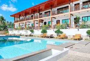 un hotel con piscina frente a un edificio en RedDoorz @ Sun Kissed Resort Guindulman en Anda