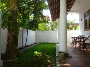 a patio with a tree and a table and a fence at Villa Unawatuna in Unawatuna
