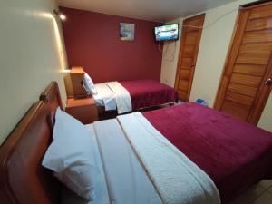 a hotel room with two beds and a flat screen tv at Casa particular in Arequipa