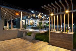 an outdoor bar with wine glasses on a patio at night at Coffee & Mist Luxury Villa- Comp Breakfast, Pool, Lounge, and Coffee Estate by StayVista in Madikeri