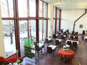 - une salle à manger avec des tables, des chaises et des fenêtres dans l'établissement APA Hotel Karuizawa Ekimae Karuizawaso, à Karuizawa