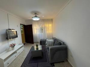 a living room with a couch and a tv at Apartamento calido in Santo Domingo