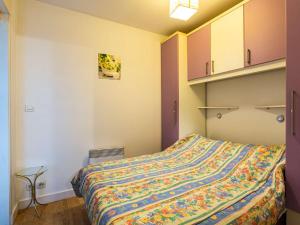 a bedroom with a bed with a colorful blanket at Appartement Hendaye, 1 pièce, 2 personnes - FR-1-2-421 in Hendaye