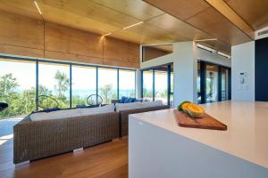 a kitchen and living room with a couch and a table at On The Edge, Luxury - KK43111 in Kaikoura +25 photos