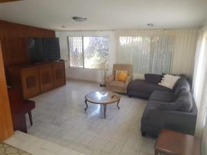 a living room with a couch and a table at Casa Cuernavaca con alberca en fraccionamiento in Cuernavaca