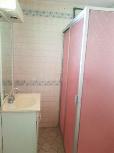 a bathroom with a red shower door next to a sink at Casa Cuernavaca con alberca en fraccionamiento in Cuernavaca