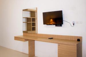 a wooden desk with a tv on a wall at Sapak Bungalow in Selong Belanak