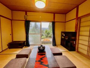 ein Wohnzimmer mit Sofas und einem großen Fenster in der Unterkunft ワイルドライフ　森風 in Hiki
