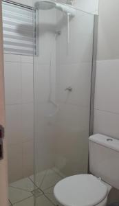 a bathroom with a toilet and a glass shower at 4 ESTAÇÕES - apto em condomínio - 2 quartos com ar condicionado in Campo Grande