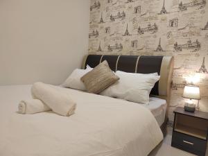 uma cama com lençóis brancos e almofadas num quarto em Gurney Duplex / 2bedrooms / 8pax em George Town