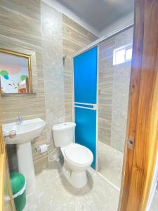 uma casa de banho com um WC e um lavatório em HOSTAL LAS FLORES em Capurganá